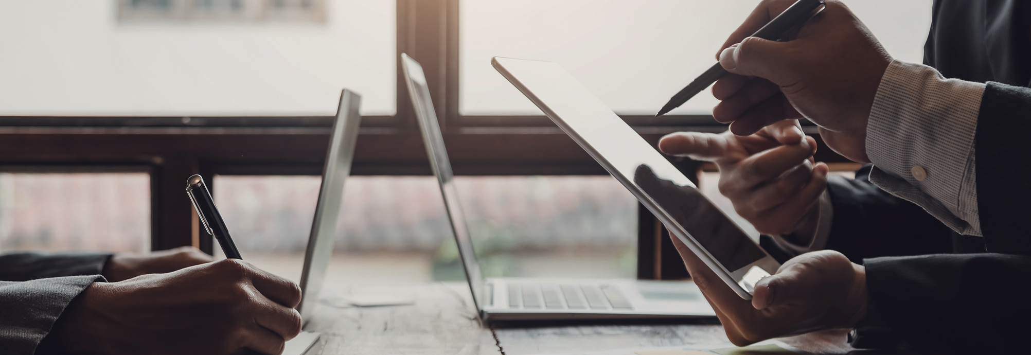 A close up of professionals pointing at an iPad.