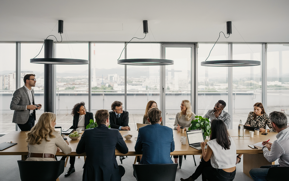 A group of financial professionals working around a board room table.