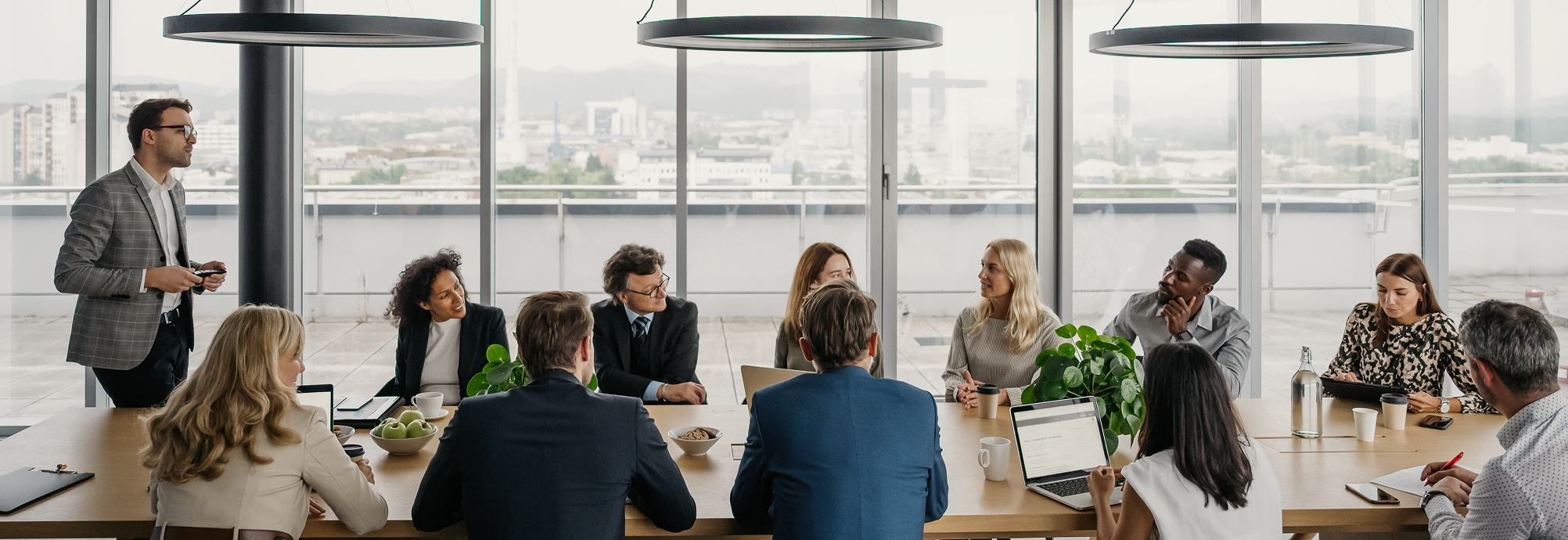 A group of financial professionals working around a board room table.