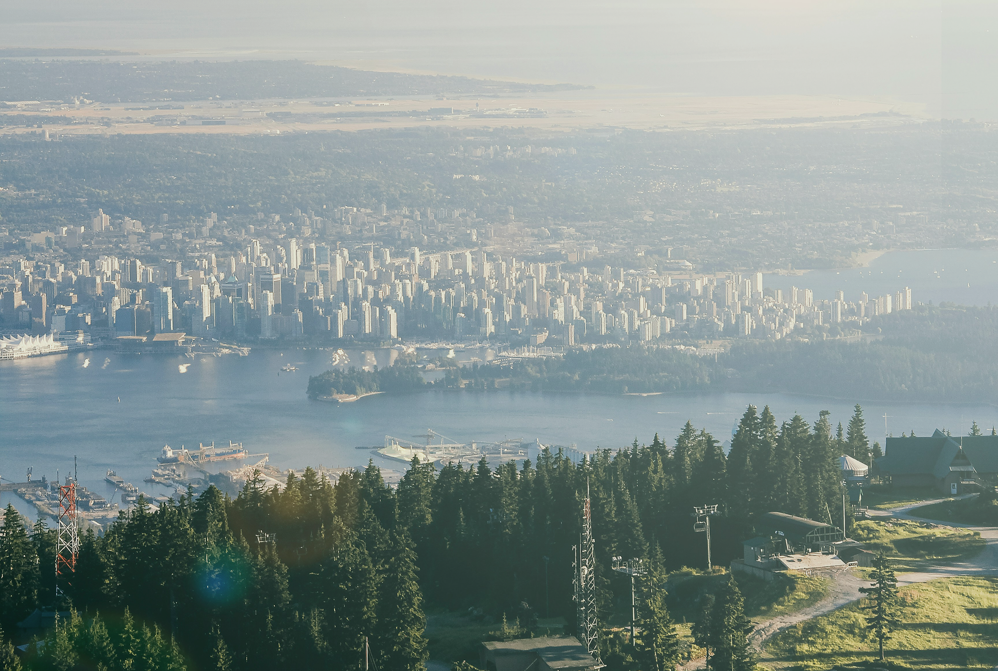 An aerial view of downtown Vancouver with mountains in the background.