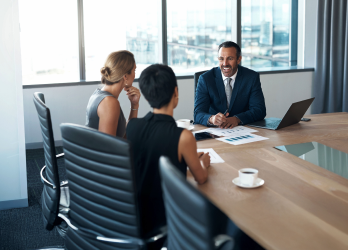 Three people working in a boardroom.
