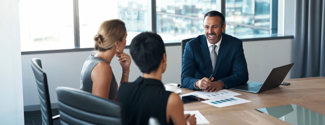 Three people working in a boardroom.