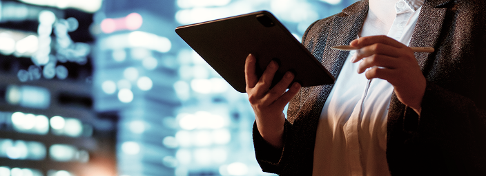 A close-up of a wealth professional holding their tablet in one hand and stylus in the other.