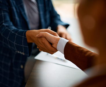 A close-up of a wealth professional and client shaking hands.